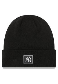 Black knitted beanie with a folded cuff, features a white rectangular logo patch with a stylized "NY" in the center. Smooth texture.