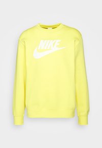 Gul sweatshirt i mjukt tyg med en stor vit Nike-logotyp över bröstet. Rund halsringning och lång ärm.