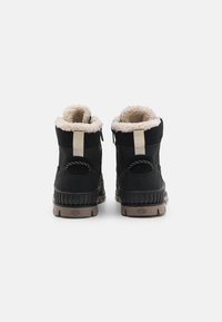 Sorte vinterstøvler med en fluffy kremfarget fôr, forsterket hæl, pull-tab og teksturert gummisåle for godt grep. Har kontrasterende sømmer.