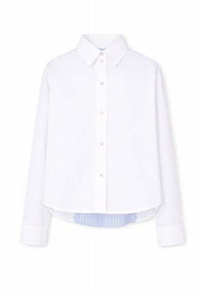 Biała koszula z długim rękawem na guziki, z ostro zakończonym kołnierzem oraz niebiesko-białym paskowanym detalem materiału wystającym spod brzegu.