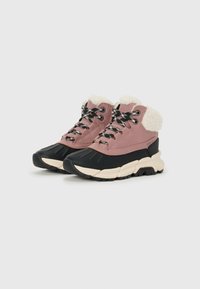 Sneaker alte rosa con suola in gomma nera, colletto peloso e lacci a motivo bianco e nero. Parte superiore testurizzata e tonalità a contrasto.