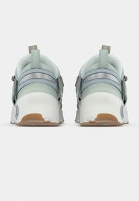 Svetlo modri supergi z teksturiranim zgornjim delom, sivimi poudarki in debelim belim podplatom z detajli iz gumijaste gume. Imajo zanko na peti za enostavno obuvanje.