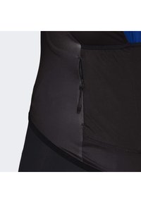 Černá sportovní podpora pasu s hladkou texturou, obsahující zip a kontrastní modrý interiér. Tvarovaný design pro lepší přizpůsobení.