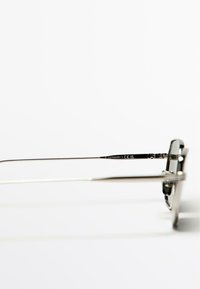 Metal solbriller med en sølvfarvet ramme, rektangulære linser og tynde arme. Indskrift på siden angiver kategori og overensstemmelse.