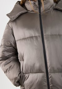 Kurtka puchowa w metalicznej tkaninie taupe, z wysokim kołnierzem, zapięciem na zamek oraz przeszytymi panelami o gładkiej, lekko błyszczącej fakturze.