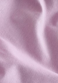 Puha levendulaszínű szövet finom kötött textúrával és lágy redőkkel, amelyek finom árnyékokat és mélységet hoznak létre.