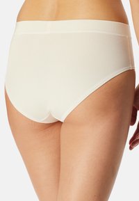 Weiße nahtlose Unterwäsche mit glatter Textur, hohem Bund und dezentem Stich, ausgestattet mit einem weichen elastischen Bund und vollständiger Abdeckung.
