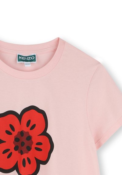 T-shirt en coton rose avec un grand motif de fleur rouge rehaussé d'accents noirs. Manches courtes et col rond. Étiquette KENZO Kids visible.