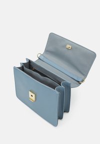 Niebieski skórzany portfel z złotymi elementami, prezentujący kwadratowy zamek, wiele przegródek i teksturowe wnętrze. Otwarty, ukazujący układ wnętrza.