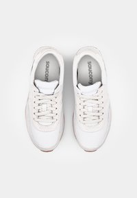 Bílé tenisky s horní částí z mesh a kůže, kulatou špičkou, šněrováním a gumovou podešví. Na jazyku a stélce je logo „Saucony“.