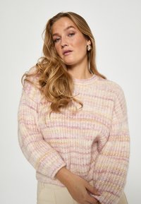 Maglione lavorato a maglia a righe rosa e bianche con scollo rotondo e maniche lunghe, dotato di una texture morbida e soffice e di una vestibilità comoda.