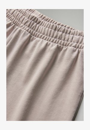 Light pink elastic waistband pants made from soft fabric with a smooth texture; features gathered details along the waistband.