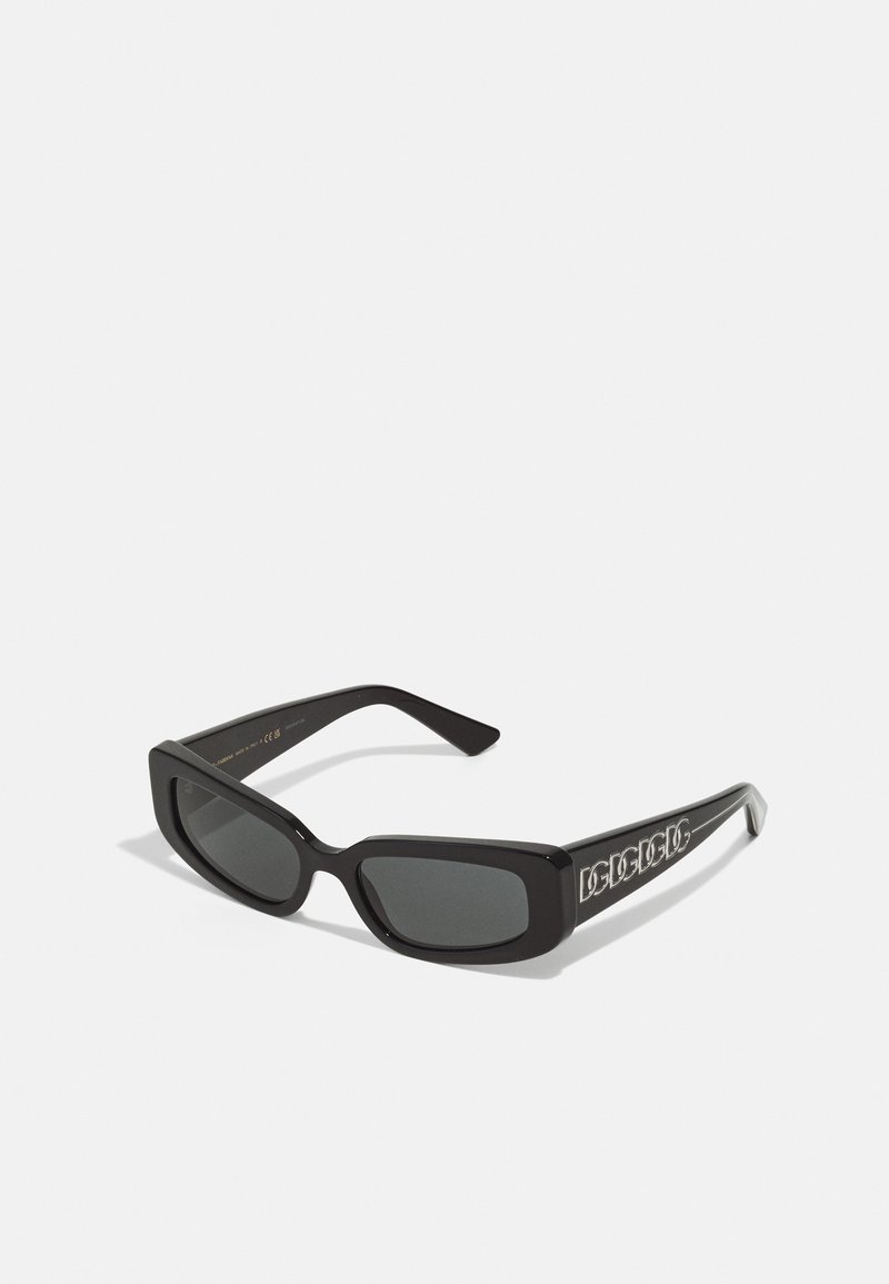 Black rectangular sunglasses with dark lenses and a glossy finish. Features bold lettering on the side temples. Frame has a thick design.
