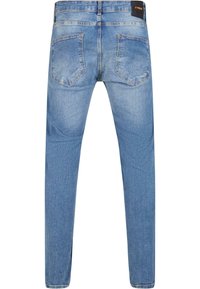 Vaaleansinisen denim-kankaan farkut, joissa on slim fit -leikkaus, viisi taskua ja näkyvät ompeluyksityiskohdat. Takana on kaksi paikkataskua ja vyötärömerkki.