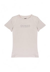 Lichtbeige t-shirt gemaakt van zachte katoen. Geribbelde ronde halslijn, korte mouwen, met het 'GUESS' logo in zilveren studs gecentreerd op de borst.