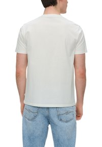 Witte t-shirt met korte mouwen van katoen, met een ronde halslijn en een relaxte pasvorm, gezien vanaf de achterkant. Gecombineerd met lichtblauwe jeans.