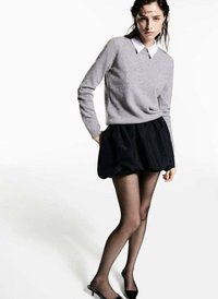 Grijs gebreid sweater, witte kraag, zwarte volumineuze rok, doorschijnende zwarte panty’s en zwarte puntige ballerina's. Eenvoudige, casual layering.