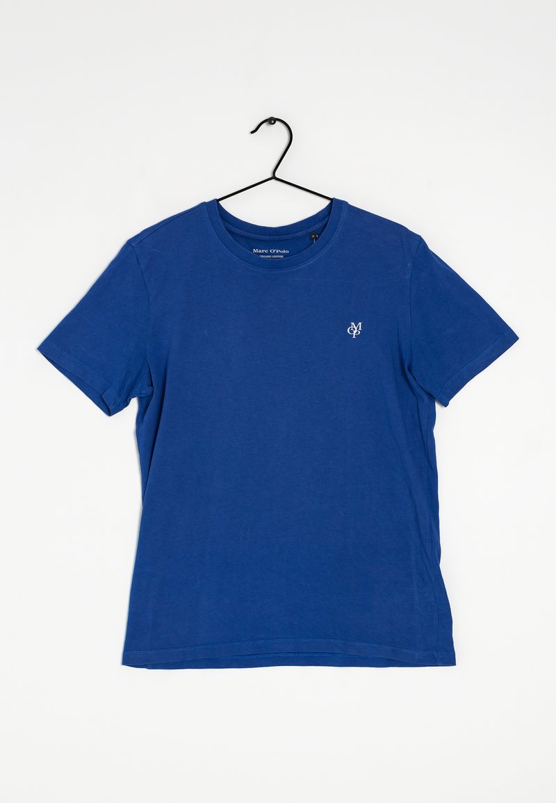 T-shirt di cotone blu con colletto rotondo e maniche corte. Presenta un piccolo logo bianco sul lato sinistro del petto. Texture morbida, design casual.