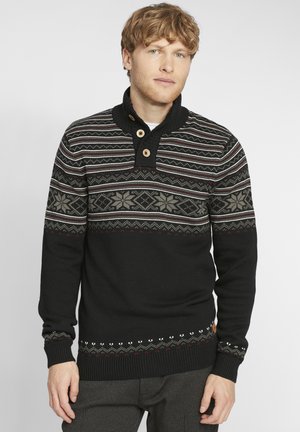 Suéter negro de punto con un cuello alto, tres botones de madera y rayas de patrón multicolor. Presenta mangas texturizadas y dobladillos con patrón.