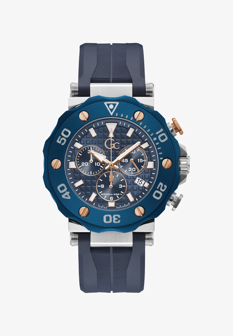 Sinine kroonograafi kell tekstureeritud dialiga, roosa kuldsete aktsentidega, roostevabast terasest kuppel ja sinine kummirihm. Veekindel kuni 100m.
