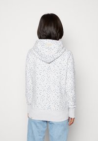 Szara bluza z kapturem w jasnym odcieniu z łezkowatym wzorem w niebieskie i różowe plamki. Posiada kieszeń kangurza oraz ściągacze na rękawach i u dołu. Wykonana z miękkiego materiału.