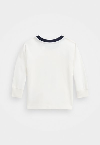 Camicia bianca a maniche lunghe con collo a girocollo blu navy. Realizzata in un tessuto morbido e con taglio dritto. Senza motivi o accenti visibili.