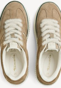 Brune ruskinds sneakers med fluffy creme farvede snørebånd, polstret krave, hvid inderside og tekstureret gummisål med et let rillemønster.