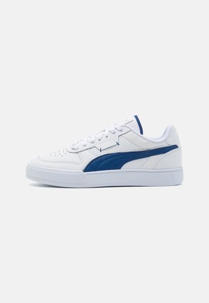White low-top sneaker with blue stripe, lace-up closure, and perforated toe box, shown in side profile on a white background.