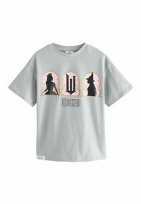 Šedé bavlnené tričko s čiernymi siluetami a ružovými oblúkmi v dizajne súvisiacom s "Wicked", s dekoratívnymi kvetinovými akcentmi.
