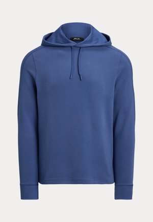 Blå langermet teksturert hettegenser med snorer og ribbestrikkede mansjetter, vist mot en ensfarget bakgrunn.