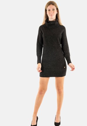 Robe pull en maille noire avec un col roulé haut, des manches longues et une silhouette ajustée. Présente une subtile brillance et un petit accent de logo.