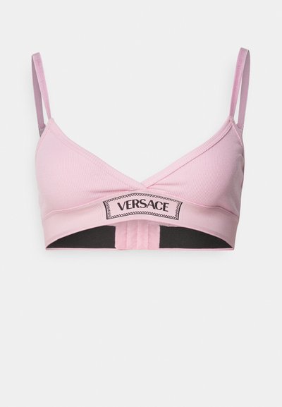 Lyserød ribbet bralette med justerbare stropper, der har et sort elastisk bånd og "VERSACE"-logoet tydeligt vist på forsiden.