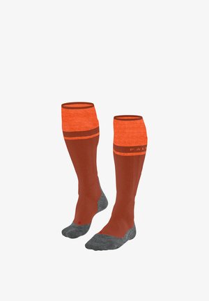 Par de calcetines hasta la rodilla en naranja y marrón con dedos y talones reforzados grises, mostrados sobre un fondo blanco.
