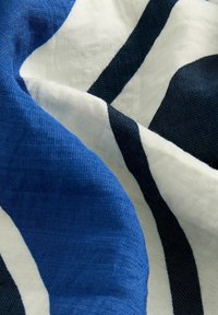 Tissu rayé bleu et blanc avec une apparence texturée et douce, présentant des lignes diagonales audacieuses en marine et crème.