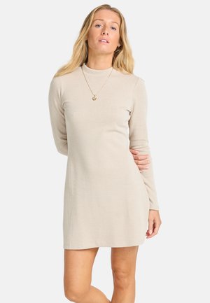 Robe beige à manches longues en ribbed avec un col haut, design ajusté et texture douce. Pas de motifs visibles, finition lisse.