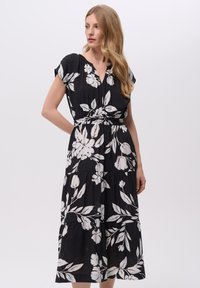 Czarna sukienka z białym wzorem kwiatowym, krótki rękaw, dekolt w serek, ściągnięta w talii, warstwowa spódnica, lekki materiał.