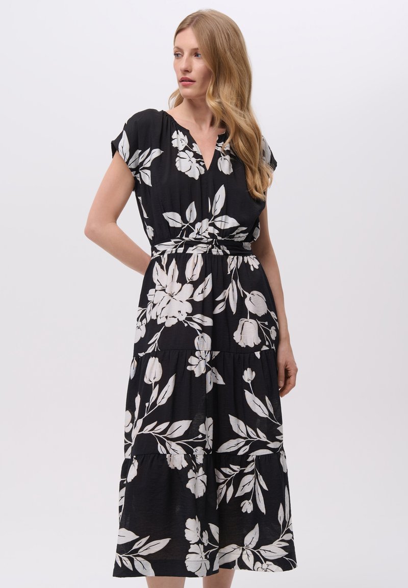 Czarna sukienka z białym wzorem kwiatowym, krótki rękaw, dekolt w serek, ściągnięta w talii, warstwowa spódnica, lekki materiał.