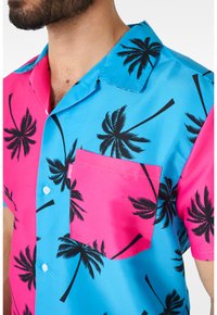 Kortærmet skjorte med et lyst blått og pink design med sorte palme mønstre. Inkluderer en lomme på venstre bryst og knaplukning.