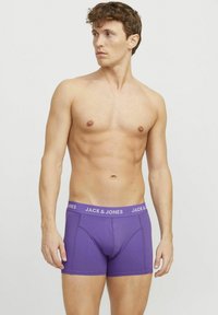 Lila pamut boxer sort struktúrált kialakítással, kontrasztos fehér derékrésszel, amelyen a "JACK & JONES" márkaneve ismétlődik.