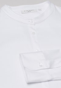 Camicia bianca aderente con colletto alla coreana, pattina con bottoni e polsini con bottoni, taglia 36 del marchio Eterna.