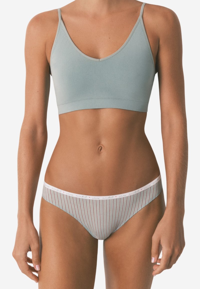 Lyseblå bh med v-halsdesign og tynde stropper; matchende stribet trusse med en hvid talje, der har røde detaljer. Glat tekstur.