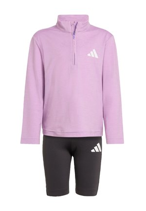 Haut zippé à manches longues violet associé à un short de vélo noir. Les deux présentent des accents de logo Adidas blanc. Tissu doux, design à coupe décontractée.