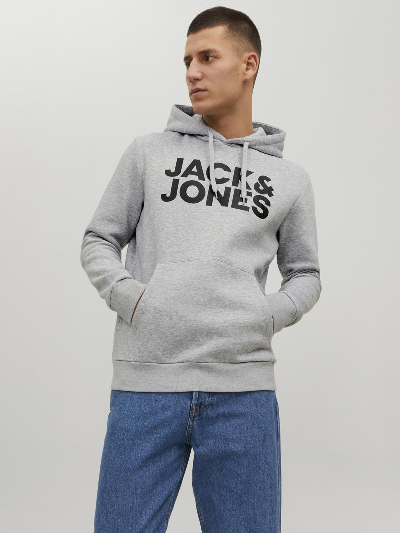 Grey pullover hoodie with drawstring, large black logo "JACK & JONES" on front, kangaroo pocket, worn with blue denim jeans.