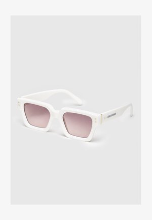 Occhiali da sole rettangolari bianchi con montature spesse e lenti sfumate rosa poggiati su una superficie semplice.
