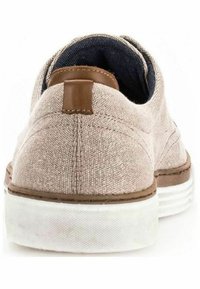 Beige Leinenschuh mit einem braunen Lederakzent an der Ferse, weißer Gummisohle und sichtbarem Denim-Futter am Öffnungsrand.