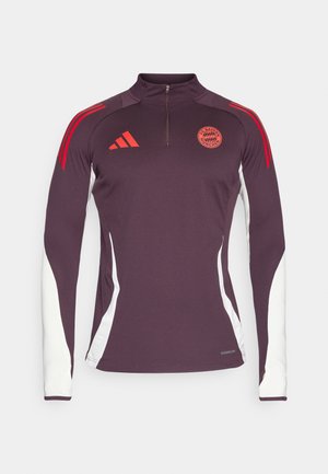 Maglia da allenamento a maniche lunghe di colore viola scuro con pannelli laterali bianchi, strisce rosse di accento e colletto con zip a un quarto; presenta il logo Adidas e il distintivo del Bayern Monaco.