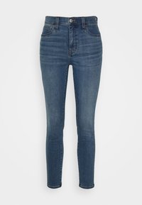 Tajta jeans i mörkblå denim med hög midja, femfickorsdesign och subtila blekningar på låren. Knapp- och dragkedjestängning.