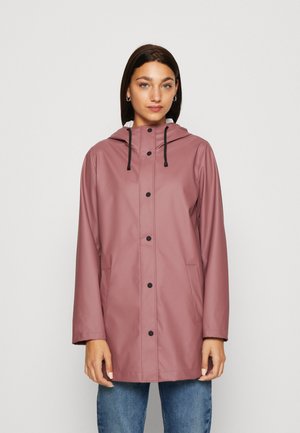Pink waterproof raincoat with a hood, snap front closure, and side pockets. Features a smooth texture and black drawstrings.