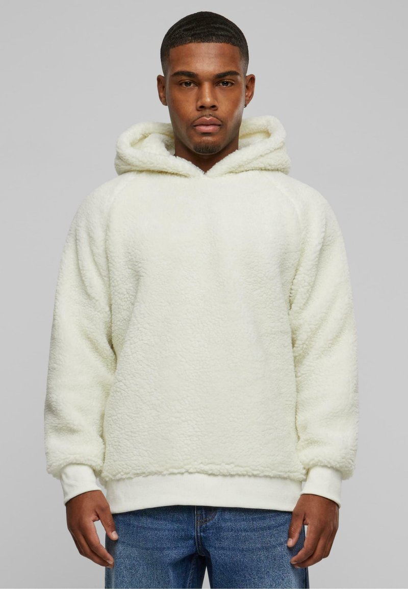 White fleece hoodie with a textured surface, featuring a drawstring hood, ribbed cuffs, and hem. Worn with blue jeans.