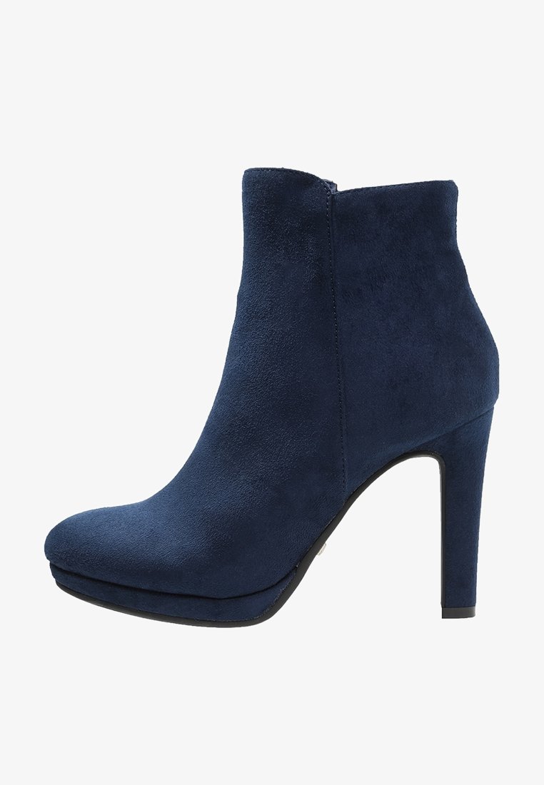 Bottine en daim bleu marine avec talon carré haut, bout arrondi et fermeture éclair latérale sur fond blanc.